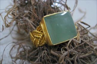 Hurant.braided gold ring with blue green stone